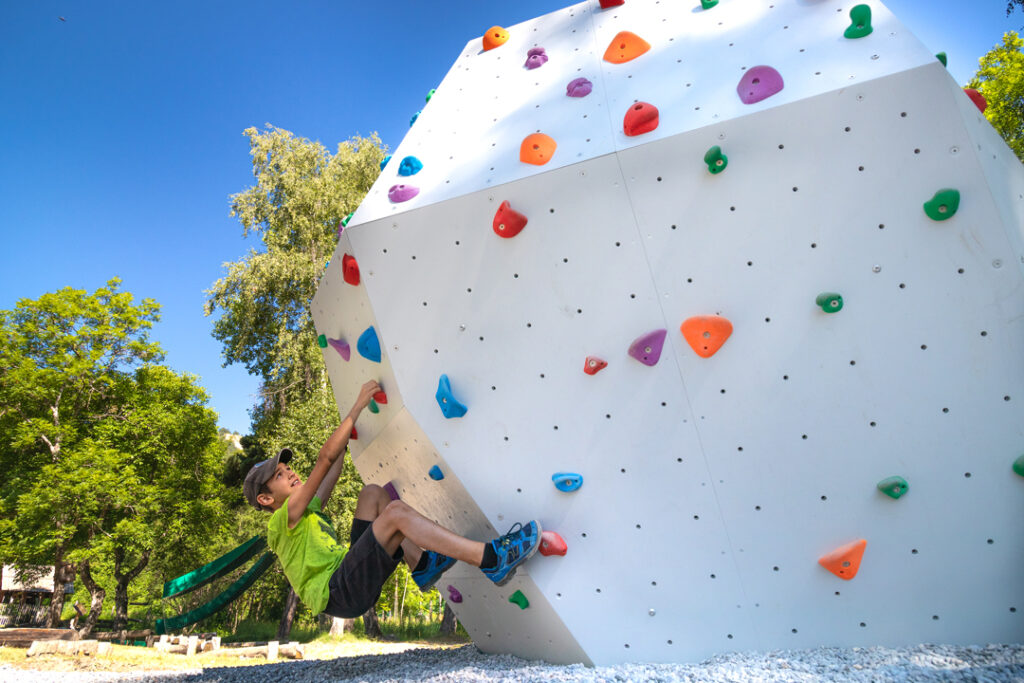 young boy starting to climb up a climbing wall