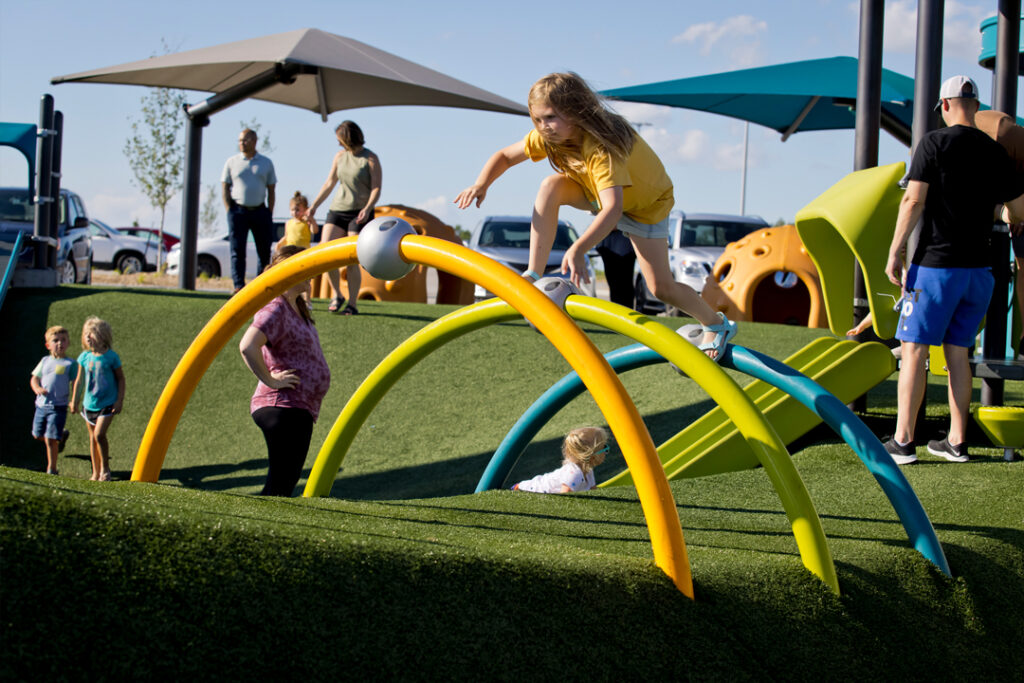 girl climbing on arches above artificial turf